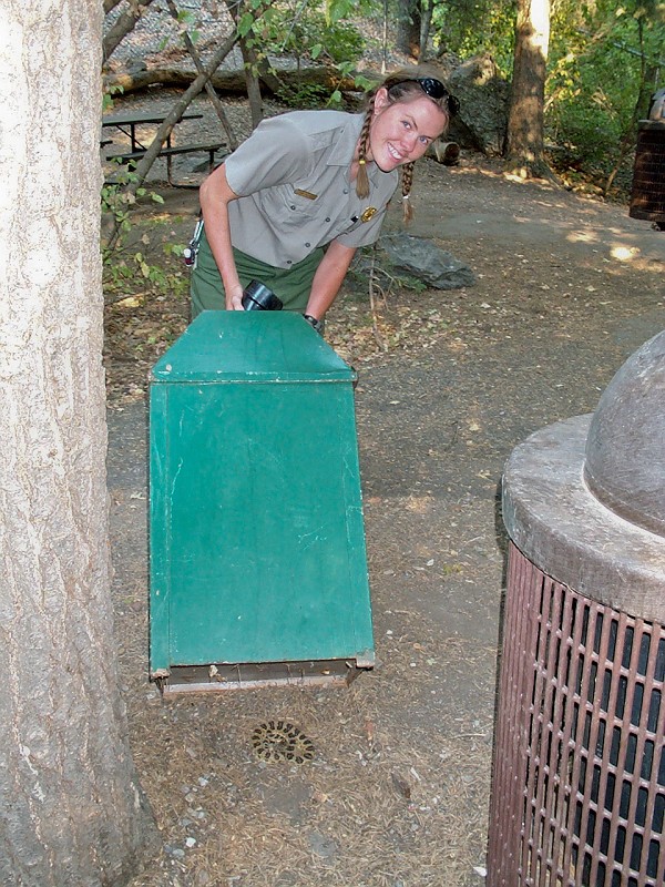 Cami Pulham showing a rattlesnake beneath a trash can.